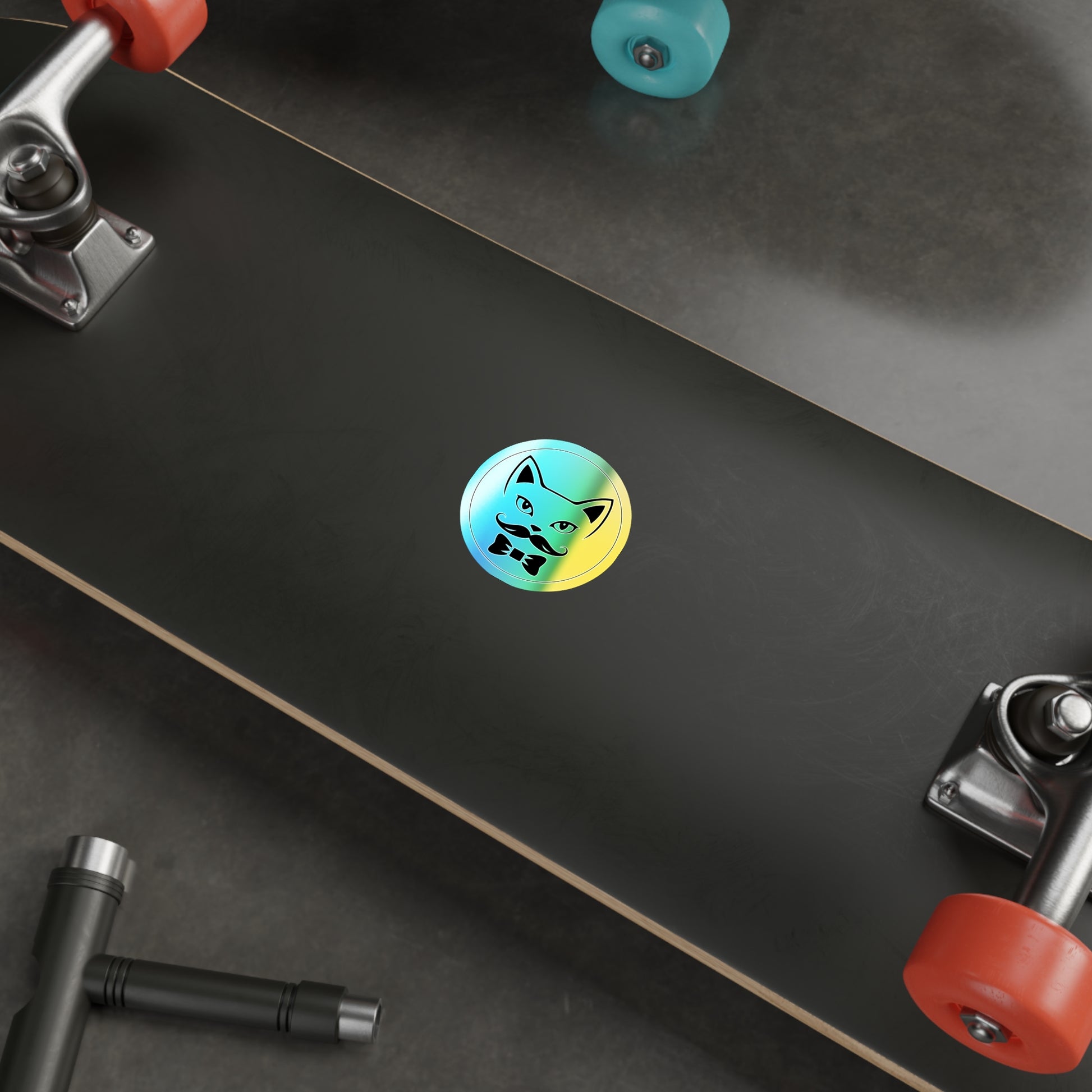Colorful sticker on a skateboard deck with visible trucks and wheels.