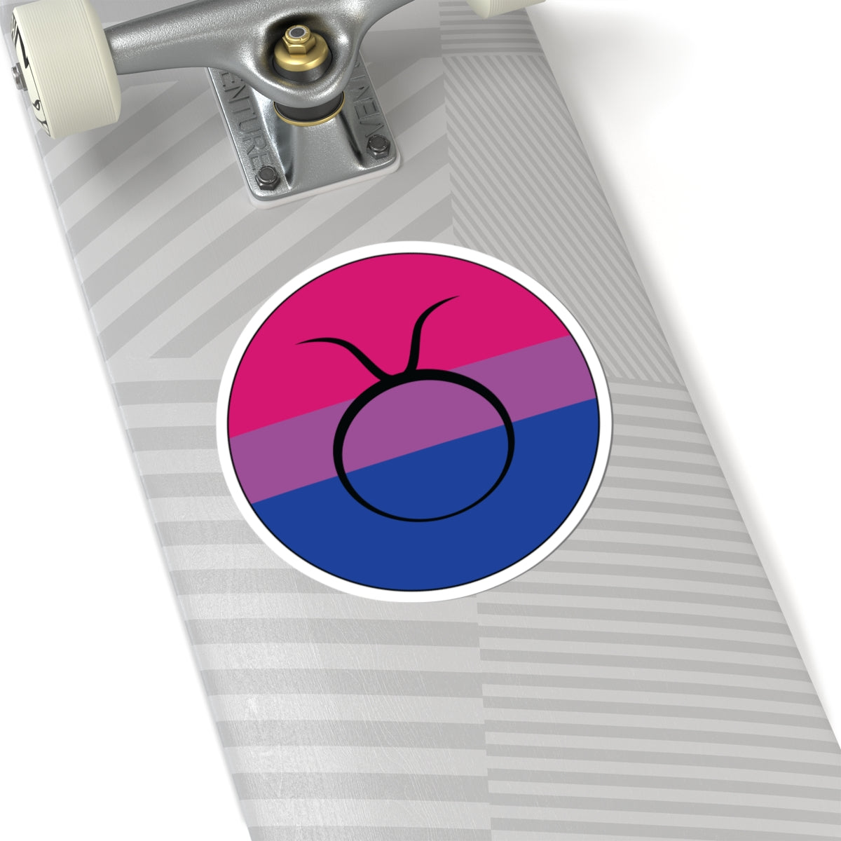 Close-up of the bottom of a silver skateboard featuring a 6 inch by 6 inch circular zodiac sticker with a centered Taurus glyph on a Bisexual pride flag style background applied to the surface.