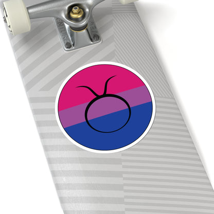Close-up of the bottom of a silver skateboard featuring a 6 inch by 6 inch circular zodiac sticker with a centered Taurus glyph on a Bisexual pride flag style background applied to the surface.