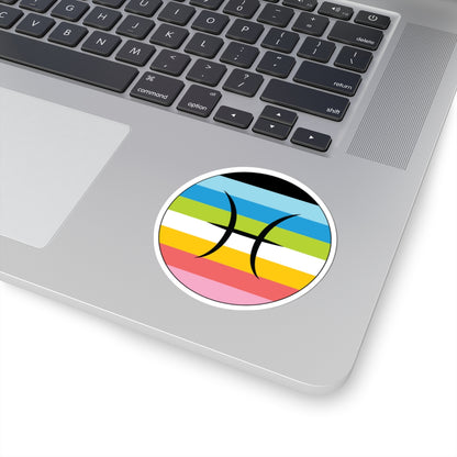 Close-up of the bottom right corner of a silver laptop featuring a 3 inch by 3 inch circular zodiac sticker with a centered Pisces glyph on a Queer pride flag style background applied to the surface.