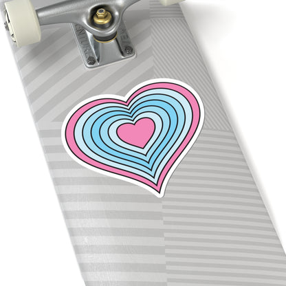 Close-up of the bottom of a silver skateboard featuring a 6 inch by 6 inch pride flag heart sticker in a Transmasc flag style applied to the surface.