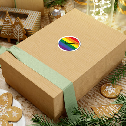 Gift box with a green ribbon on a festive background with cookies and Christmas decorations. Sagittarius Rainbow pride sticker centered on the box.