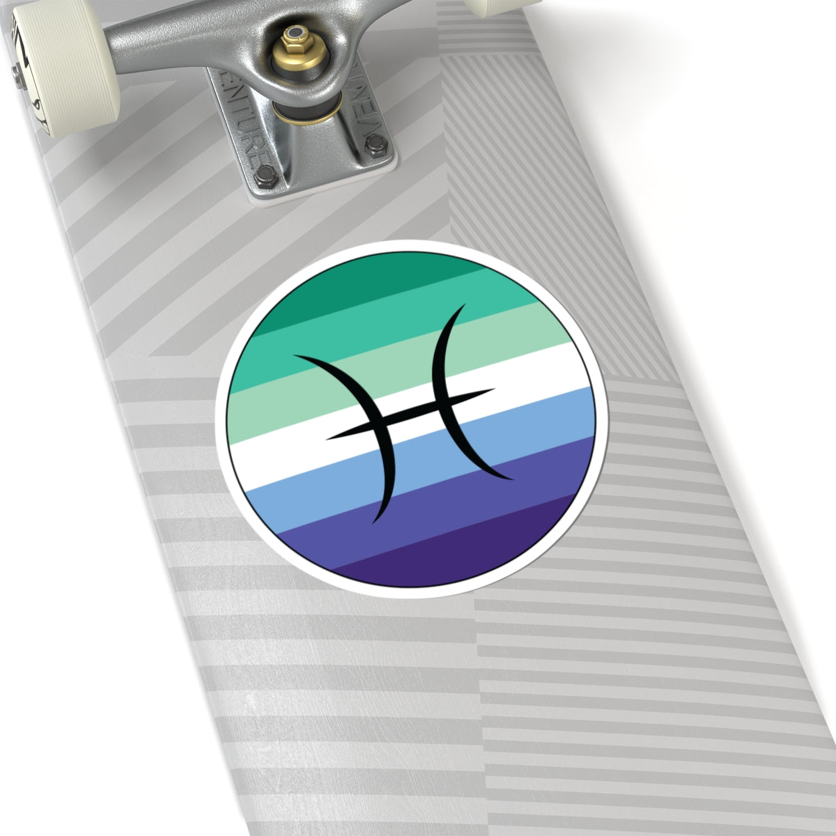 Close-up of the bottom of a silver skateboard featuring a 6 inch by 6 inch circular zodiac sticker with a centered Pisces glyph on a Gay Men pride flag style background applied to the surface.