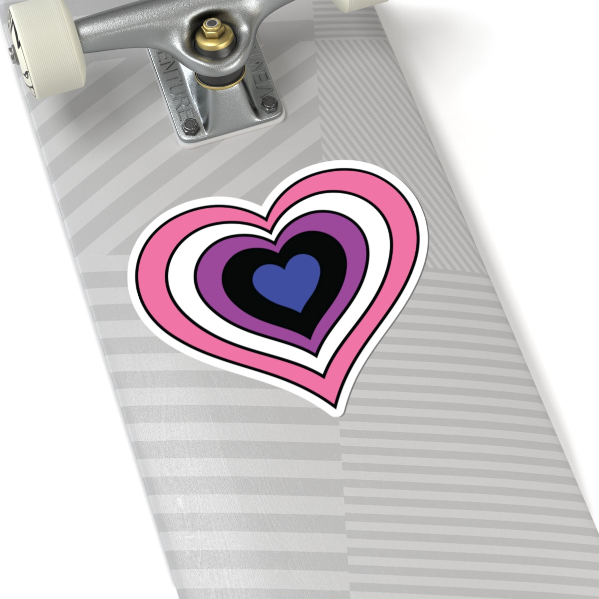Close-up of the bottom of a silver skateboard featuring a 6 inch by 6 inch pride flag heart sticker in a Genderfluid flag style applied to the surface.