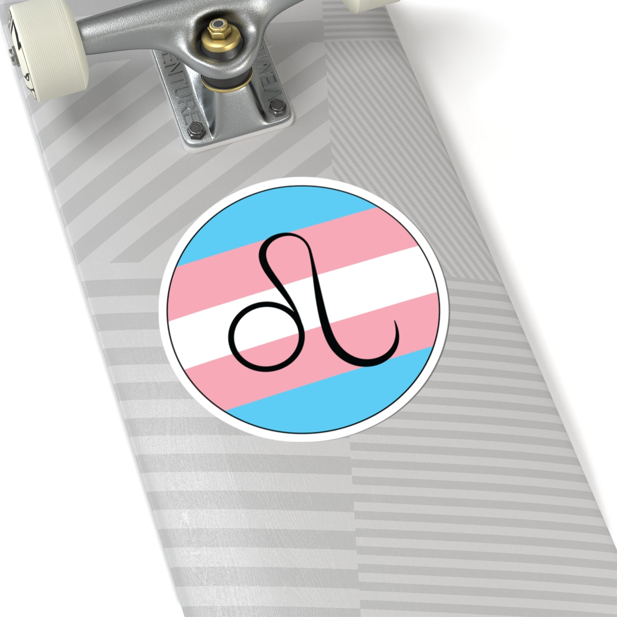 Close-up of the bottom of a silver skateboard featuring a 6 inch by 6 inch circular zodiac sticker with a centered Leo glyph on a Transgender pride flag style background applied to the surface.