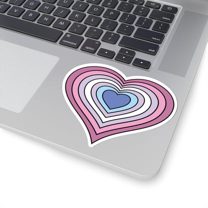 Close-up of the bottom right corner of a silver laptop featuring a 4 inch by 4 inch pride flag heart sticker in a Bigender flag style applied to the surface.
