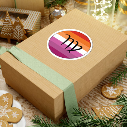 Gift box with a green ribbon on a festive background with cookies and Christmas decorations. Virgo Lesbian pride sticker centered on the box.