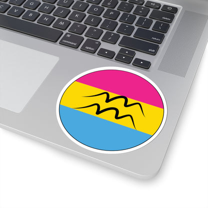 Close-up of the bottom right corner of a silver laptop featuring a 4 inch by 4 inch circular zodiac sticker with a centered Aquarius glyph on a Pansexual pride flag style background applied to the surface.