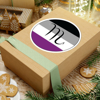 Gift box with a green ribbon on a festive background with cookies and Christmas decorations. Scorpio Asexual pride sticker centered on the box.