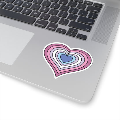 Close-up of the bottom right corner of a silver laptop featuring a 3 inch by 3 inch pride flag heart sticker in a Bigender flag style applied to the surface.