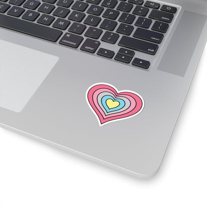 Close-up of the bottom right corner of a silver laptop featuring a 2 inch by 2 inch pride flag heart sticker in a Genderflux flag style applied to the surface.