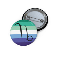 Front and back view of a circular gay men pride flag button featuring the Capricorn zodiac symbol in black centered on the front.