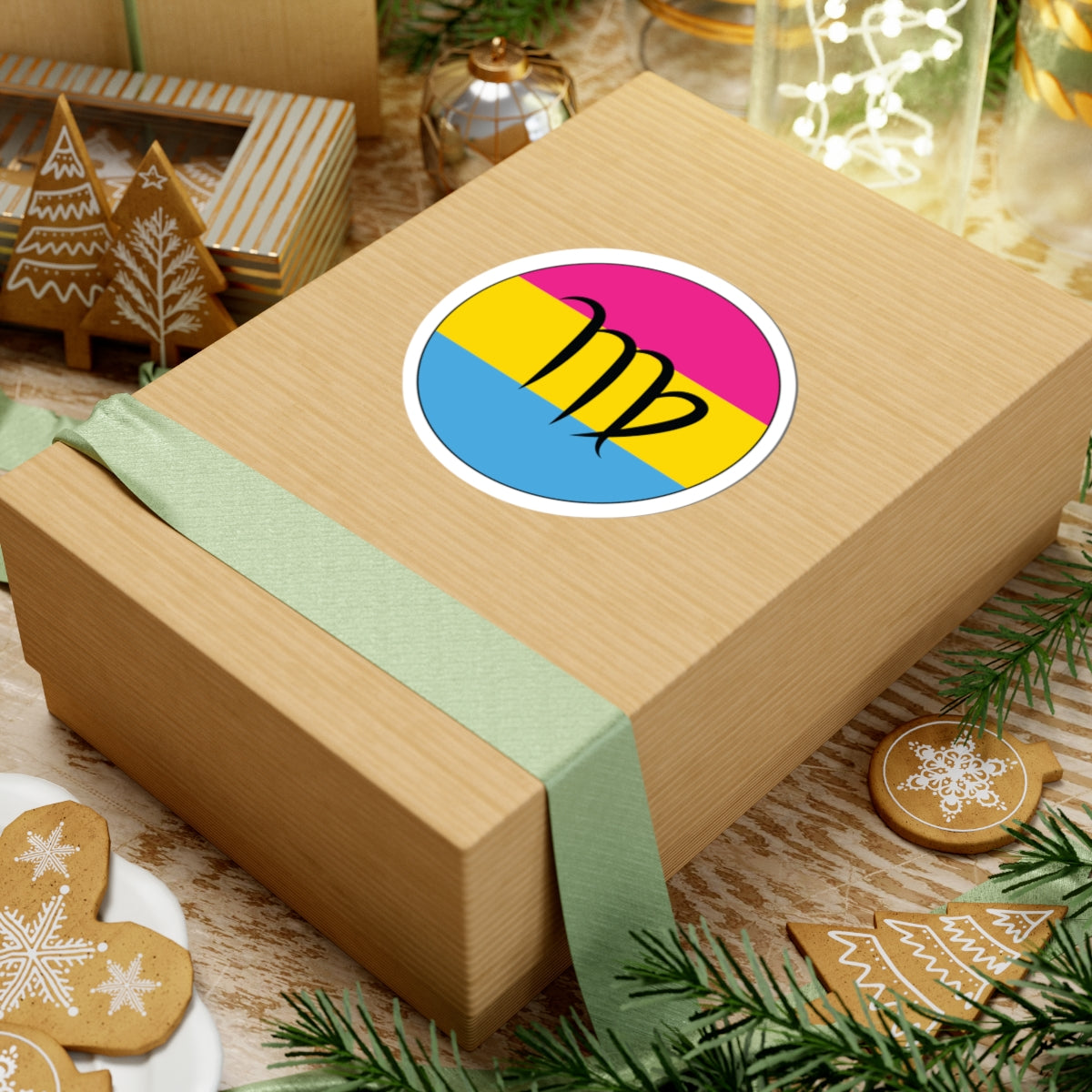 Gift box with a green ribbon on a festive background with cookies and Christmas decorations. Virgo Pansexual pride sticker centered on the box.