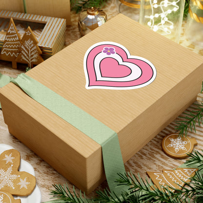 Gift box with a green ribbon on a festive background with cookies and Christmas decorations. Sapphic pride heart sticker centered on the box.