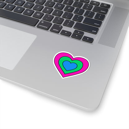 Close-up of the bottom right corner of a silver laptop featuring a 2 inch by 2 inch pride flag heart sticker in a Polysexual flag style applied to the surface.