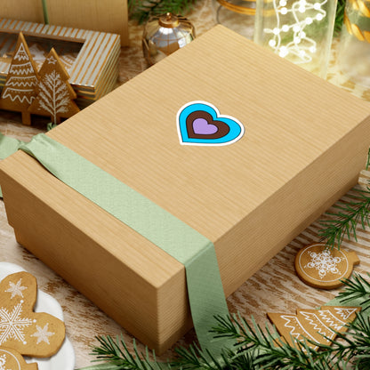 Gift box with a green ribbon on a festive background with cookies and Christmas decorations. Heart-shaped Androsexual pride sticker centered on the box.