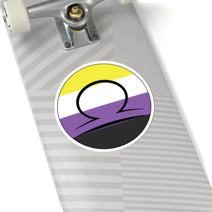 Close-up of the bottom of a silver skateboard featuring a 6 inch by 6 inch circular zodiac sticker with a centered Libra glyph on a Nonbinary pride flag style background applied to the surface.
