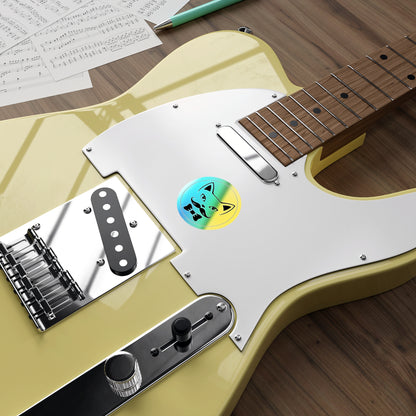 Close-up of a guitar body with a pickguard and control knobs on a wooden surface. Holographic Queer Kitty sticker on the body of the guitar.