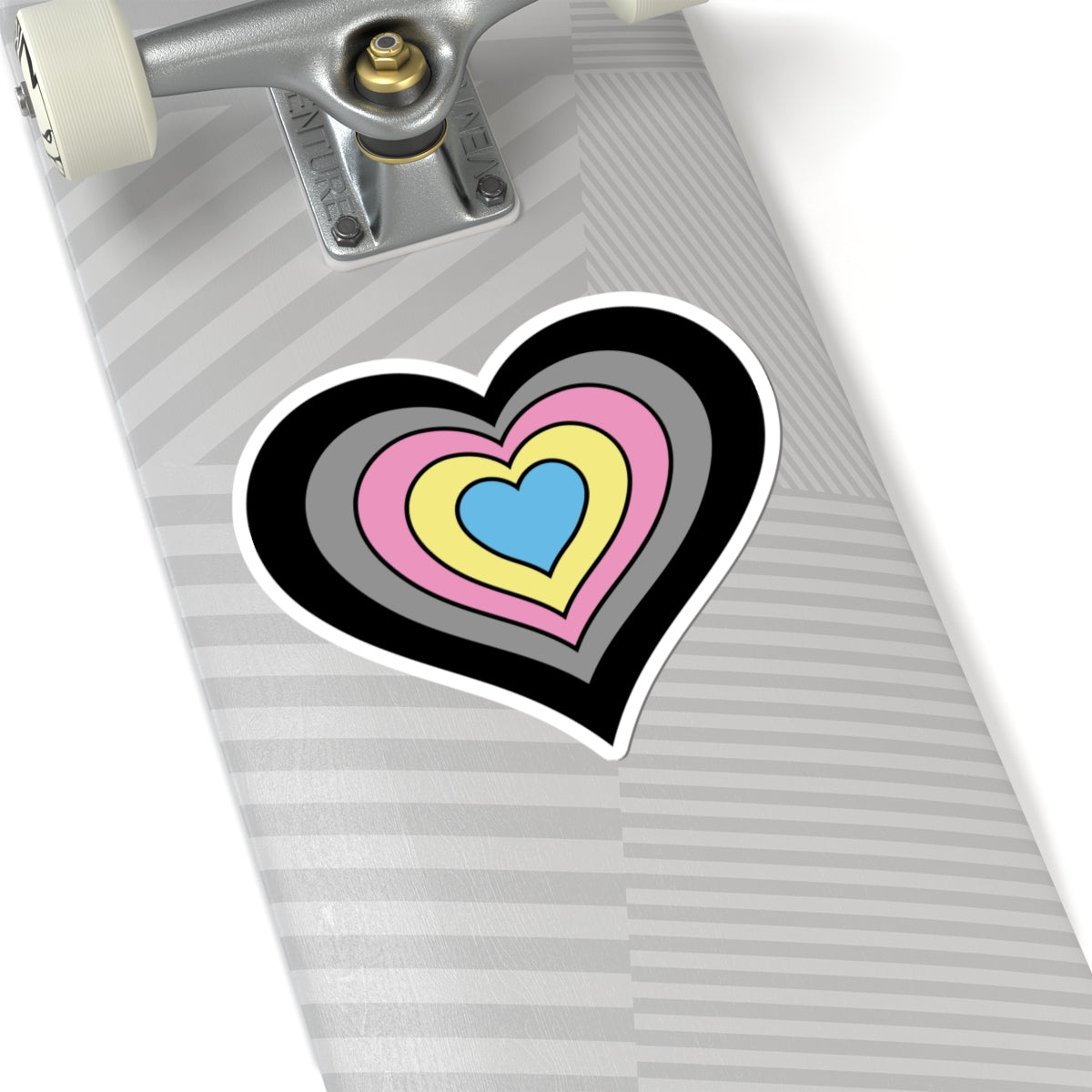 Close-up of the bottom of a silver skateboard featuring a 6 inch by 6 inch pride flag heart sticker in a Polygender flag style applied to the surface.