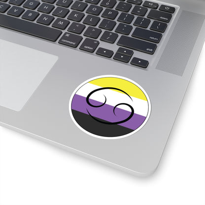Close-up of the bottom right corner of a silver laptop featuring a 3 inch by 3 inch circular zodiac sticker with a centered Leo glyph on a Nonbinary pride flag style background applied to the surface.