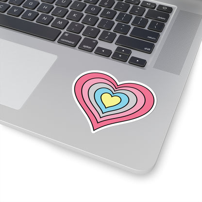 Close-up of the bottom right corner of a silver laptop featuring a 3 inch by 3 inch pride flag heart sticker in a Genderflux flag style applied to the surface.