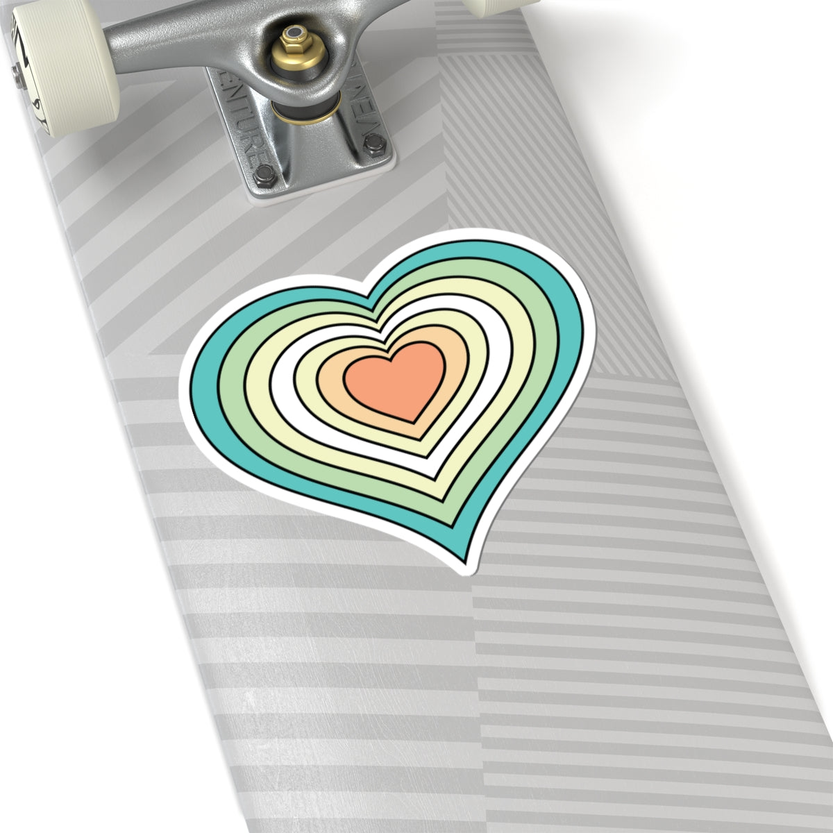 Close-up of the bottom of a silver skateboard featuring a 6 inch by 6 inch pride flag heart sticker in a Genderfloren flag style applied to the surface.
