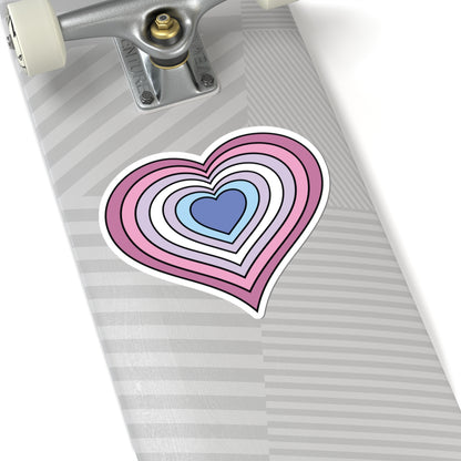 Close-up of the bottom of a silver laptop featuring a 6 inch by 6 inch pride flag heart sticker in a Bigender flag style applied to the surface.