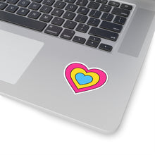 Close-up of the bottom right corner of a silver laptop featuring a 2 inch by 2 inch pride flag heart sticker in a Pansexual flag style applied to the surface.