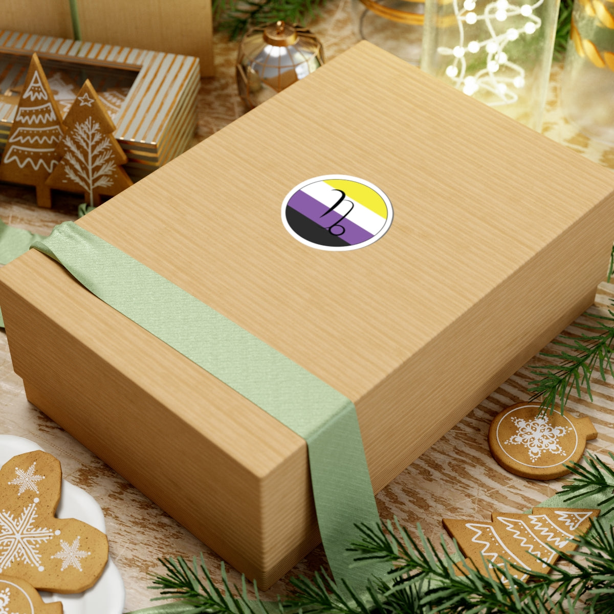 Gift box with a green ribbon on a festive background with cookies and Christmas decorations. Capricorn Nonbinary pride sticker centered on the box.