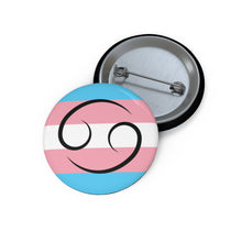 Front and back view of a circular transgender pride flag button featuring the Cancer zodiac symbol in black centered on the front.