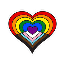 Heart-shaped intersex-inclusive progress pride flag sticker featuring nested heart stripes in black, brown, light blue, pink, and white on the bottom half with a purple center heart, and stripes of red, orange, yellow, green, and blue on the top half - outlined with a thin black border and a white sticker border. The sticker is shown on a white background.