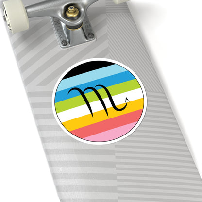 Close-up of the bottom of a silver skateboard featuring a 6 inch by 6 inch circular zodiac sticker with a centered Scorpio glyph on a Queer pride flag style background applied to the surface.