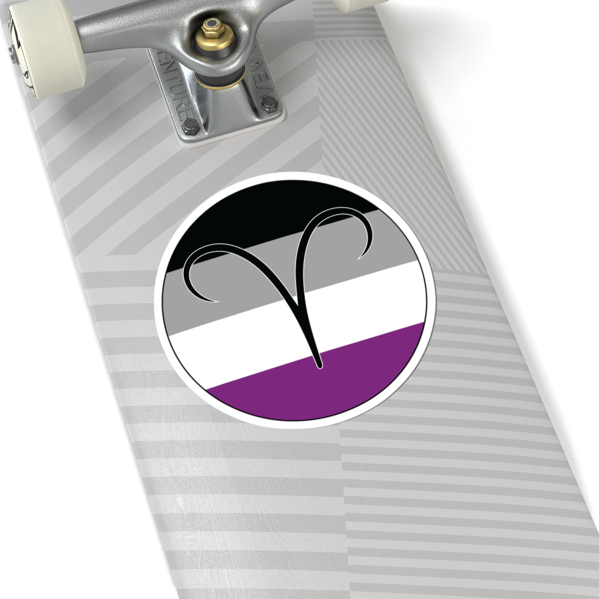Close-up of the bottom of a silver skateboard featuring a 6 inch by 6 inch circular zodiac sticker with a centered Aires glyph on an Asexual pride flag style background applied to the surface.
