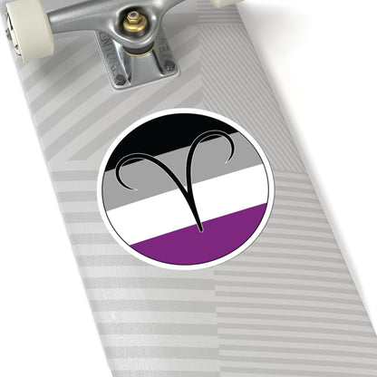Close-up of the bottom of a silver skateboard featuring a 6 inch by 6 inch circular zodiac sticker with a centered Aires glyph on an Asexual pride flag style background applied to the surface.