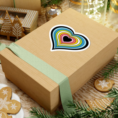 Gift box with a green ribbon on a festive background with cookies and Christmas decorations. Heart-shaped Queer pride sticker centered on the box.