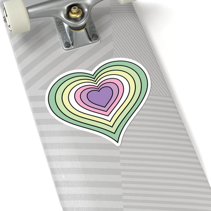 Close-up of the bottom of a silver skateboard featuring a 6 inch by 6 inch pride flag heart sticker in a Genderfae flag style applied to the surface.