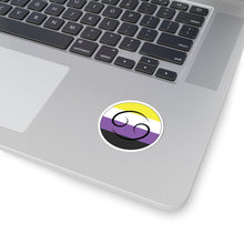 Close-up of the bottom right corner of a silver laptop featuring a 2 inch by 2 inch circular zodiac sticker with a centered Leo glyph on a Nonbinary pride flag style background applied to the surface.