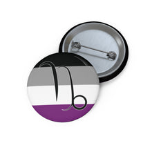 Front and back view of a circular asexual pride flag button featuring the Capricorn zodiac symbol in black centered on the front.