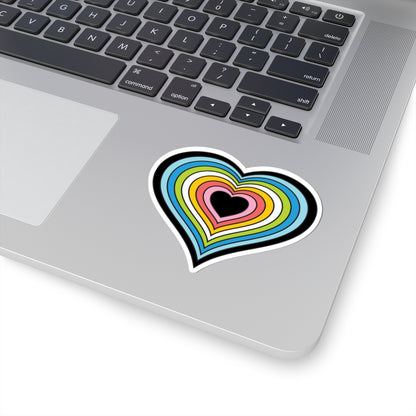 Close-up of the bottom right corner of a silver laptop featuring a 3 inch by 3 inch pride flag heart sticker in a Queer flag style applied to the surface.