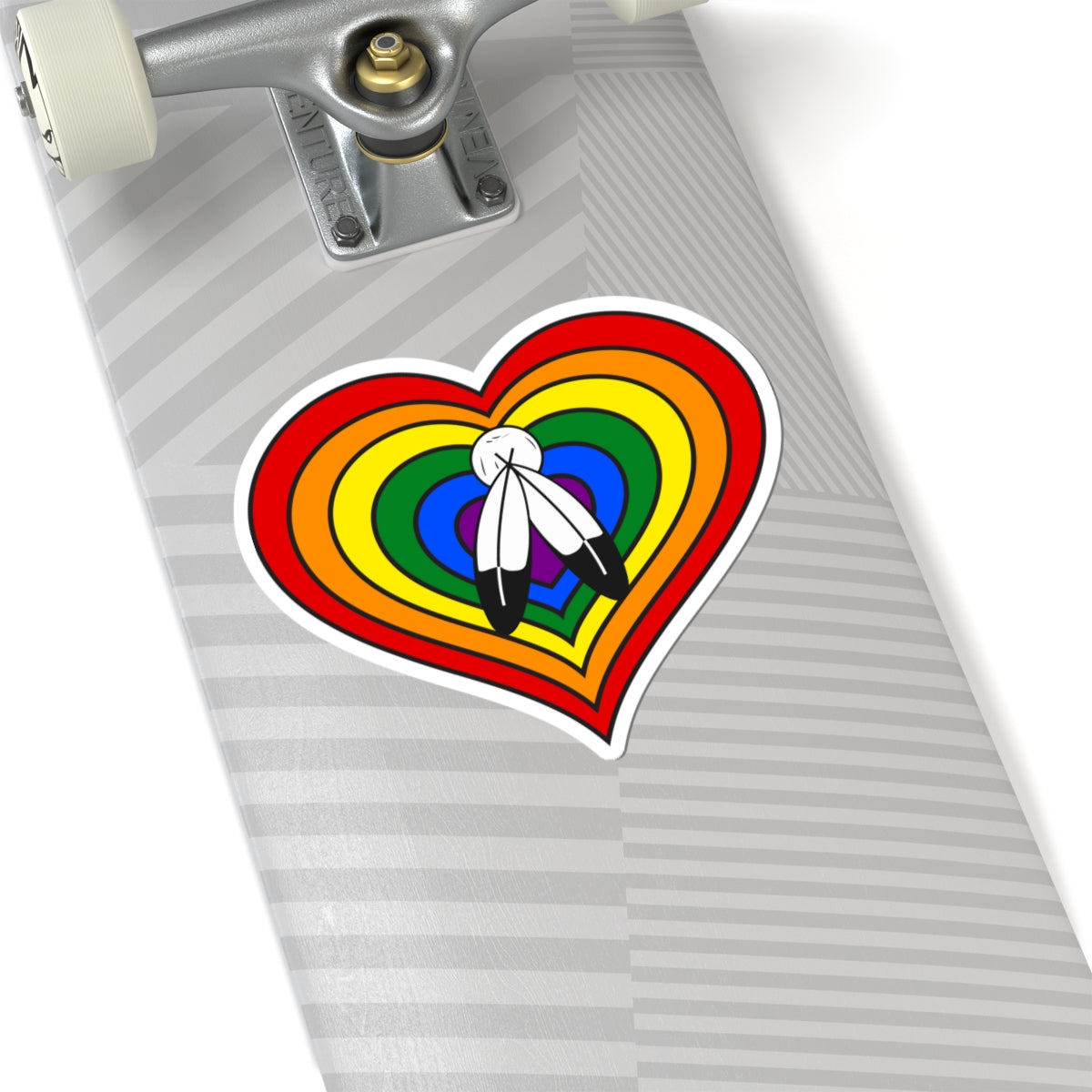Close-up of the bottom of a silver skateboard featuring a 6 inch by 6 inch pride flag heart sticker in a Two-Spirit flag style applied to the surface.