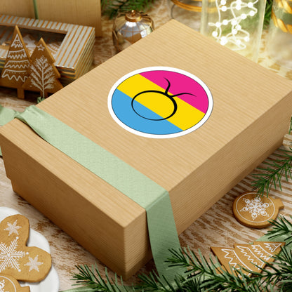 Gift box with a green ribbon on a festive background with cookies and Christmas decorations. Taurus Pansexual pride sticker centered on the box.