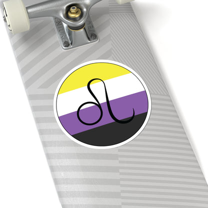 Close-up of the bottom of a silver skateboard featuring a 6 inch by 6 inch circular zodiac sticker with a centered Leo glyph on a Nonbinary pride flag style background applied to the surface.