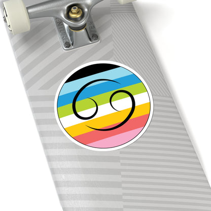 Close-up of the bottom of a silver skateboard featuring a 6 inch by 6 inch circular zodiac sticker with a centered Cancer glyph on a Queer pride flag style background applied to the surface.
