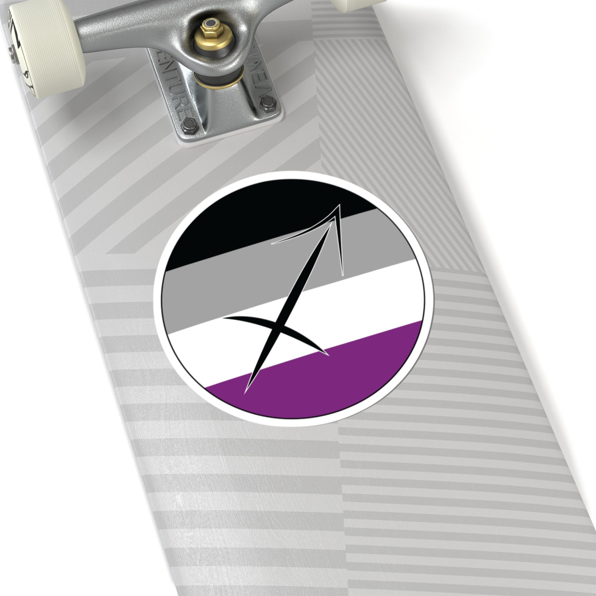 Close-up of the bottom of a silver skateboard featuring a 6 inch by 6 inch circular zodiac sticker with a centered Sagittarius glyph on an Asexual pride flag style background applied to the surface.