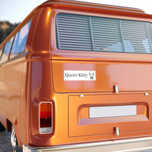 Orange van with a white Queer Kitty bumper sticker on the back