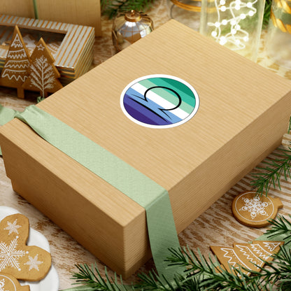Gift box with a green ribbon on a festive background with cookies and Christmas decorations. Libra Gay Men pride sticker centered on the box.
