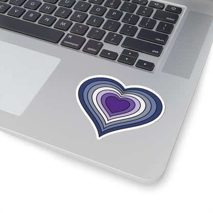 Close-up of the bottom right corner of a silver laptop featuring a 3 inch by 3 inch pride flag heart sticker in a purple butch pride flag style applied to the surface.
