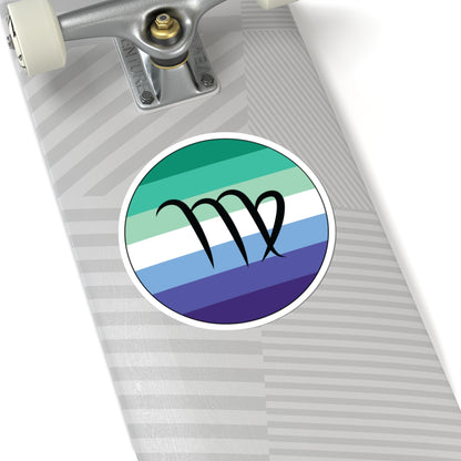 Close-up of the bottom of a silver skateboard featuring a 6 inch by 6 inch circular zodiac sticker with a centered Virgo glyph on a Gay Men pride flag style background applied to the surface.