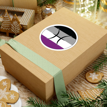 Gift box with a green ribbon on a festive background with cookies and Christmas decorations. Pisces Asexual pride sticker centered on the box.