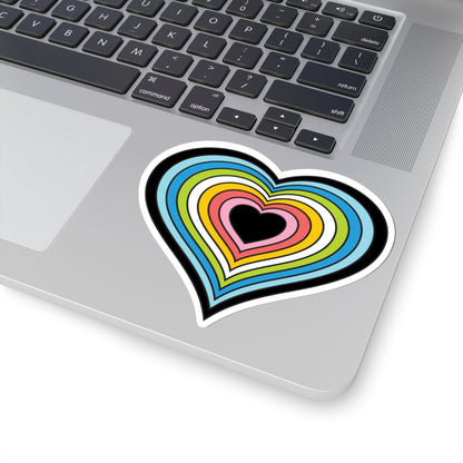 Close-up of the bottom right corner of a silver laptop featuring a 4 inch by 4 inch pride flag heart sticker in a Queer flag style applied to the surface.